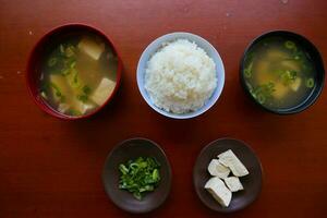 miso sopa o japonés miso sopa en cuenco en el mesa. japonés cocina en el formar de sopa con dashi ingredientes, tofu, mariscos, verduras, y coronado con miso a gusto foto