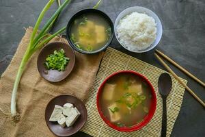 miso soup or Japanese miso soup in bowl on the table. Japanese cuisine in the form of soup with dashi ingredients, tofu, seafood, vegetables, and topped with miso to taste photo