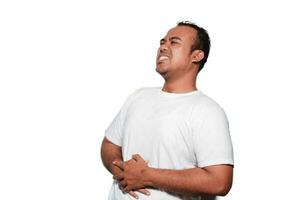 Photo of young unwell sick ill man with tshirt hold hand on stomach suffers pain isolated on white background