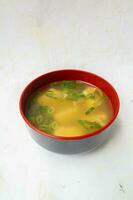 miso soup or Japanese miso soup in bowl on the table. Japanese cuisine in the form of soup with dashi ingredients, tofu, seafood, vegetables, and topped with miso to taste photo