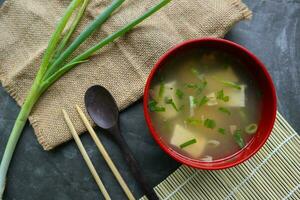 miso sopa o japonés miso sopa en cuenco en el mesa. japonés cocina en el formar de sopa con dashi ingredientes, tofu, mariscos, verduras, y coronado con miso a gusto foto