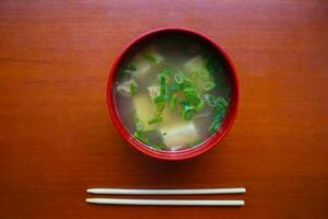 miso sopa o japonés miso sopa en cuenco en el mesa. japonés cocina en el formar de sopa con dashi ingredientes, tofu, mariscos, verduras, y coronado con miso a gusto foto