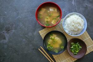 miso sopa o japonés miso sopa en cuenco en el mesa. japonés cocina en el formar de sopa con dashi ingredientes, tofu, mariscos, verduras, y coronado con miso a gusto foto