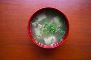 miso soup or Japanese miso soup in bowl on the table. Japanese cuisine in the form of soup with dashi ingredients, tofu, seafood, vegetables, and topped with miso to taste photo