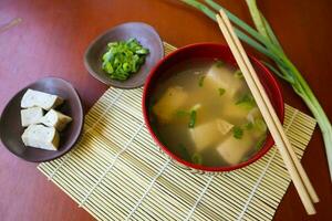 miso sopa o japonés miso sopa en cuenco en el mesa. japonés cocina en el formar de sopa con dashi ingredientes, tofu, mariscos, verduras, y coronado con miso a gusto foto