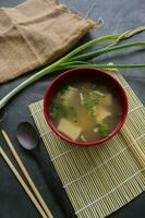 miso soup or Japanese miso soup in bowl on the table. Japanese cuisine in the form of soup with dashi ingredients, tofu, seafood, vegetables, and topped with miso to taste photo