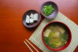 miso soup or Japanese miso soup in bowl on the table. Japanese cuisine in the form of soup with dashi ingredients, tofu, seafood, vegetables, and topped with miso to taste photo