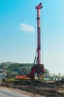 Powerful hydraulic machine drilling rig on a construction site. Installation of bored piles by drilling. Pile foundations. Drilling in the ground photo