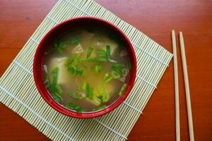 miso sopa o japonés miso sopa en cuenco en el mesa. japonés cocina en el formar de sopa con dashi ingredientes, tofu, mariscos, verduras, y coronado con miso a gusto foto