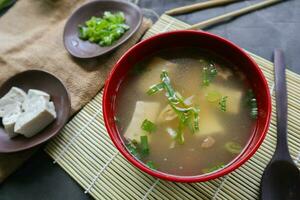 miso soup or Japanese miso soup in bowl on the table. Japanese cuisine in the form of soup with dashi ingredients, tofu, seafood, vegetables, and topped with miso to taste photo