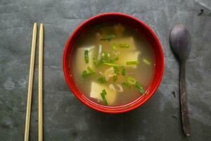 miso soup or Japanese miso soup in bowl on the table. Japanese cuisine in the form of soup with dashi ingredients, tofu, seafood, vegetables, and topped with miso to taste photo