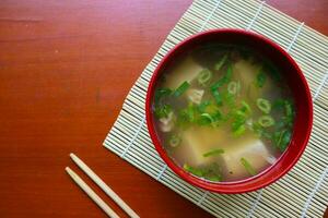 miso sopa o japonés miso sopa en cuenco en el mesa. japonés cocina en el formar de sopa con dashi ingredientes, tofu, mariscos, verduras, y coronado con miso a gusto foto