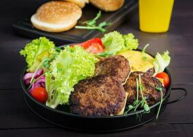 Burger cooking - burger with beef,  tomato, cheese, pickled cucumber and red onion on plate photo