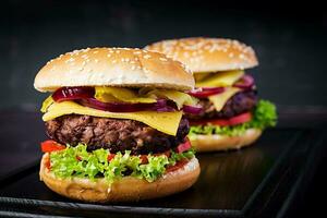 Big sandwich - hamburger burger with beef,  tomato, cheese, pickled cucumber and red onion. photo