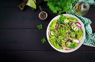 Healthy vegan food. Vegetarian vegetable salad of radish, cucumbers, lettuce  and red onion.  Top view, copy space photo