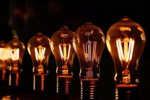 One row of electric light bulbs glowing on a black background, . photo