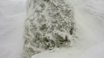 snö skikten ackumuleras på sten i de hård stormig kall väder i vinter- video