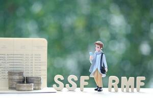 Man and stack of coins money on natural green background photo