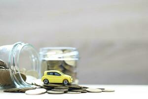 Miniature car model on growing stack of coins money on white background, Saving money for car, Finance and car loan, Investment and business concept photo