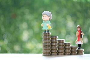 Retirement planning, Senior standing on stack of coins money on natural green background, Save money for prepare in future and pension retirement concept photo