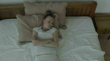 une femme dans blanc un pantalon est pose sur une lit video