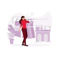 The woman who owns a boutique stands and talks on her cell phone in her boutique. Trend Modern vector flat illustration.