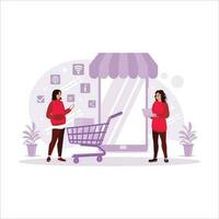 A small cardboard box with a shopping trolley on a laptop computer for online shopping. Two women are shopping online. Trend Modern vector flat illustration