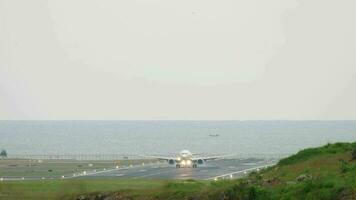 Visão do a pista às phuket aeroporto. a avião chegado em a ilha do tailândia. avião aterrissagem em a fundo do a oceano video