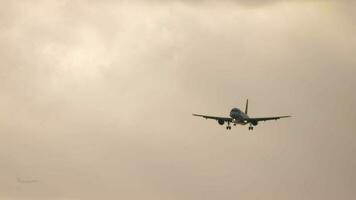 Unidentified passenger jet aircraft approaching landing against golden sunset sky. Aircraft arrive at sunset. video