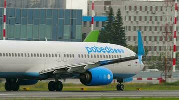 NOVOSIBIRSK, RUSSIAN FEDERATION JULY 15, 2022 - Passenger jet plane Boeing 737 of Pobeda Air takeoff, departure, rear view. Tourism and travel concept video