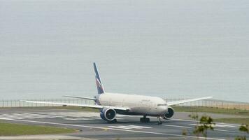 phuket, Tailândia novembro 27, 2017 - comercial avião boeing 777 do aeroflot em pista às phuket aeroporto. corpo largo quadro, mar fundo. turismo e viagem conceito video