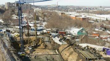 Construction of an apartment building. Builders work on the construction site. Construction crane works on the winter video