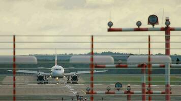 passagiersvliegtuig arriveert Bij dusseldorf luchthaven dus. voorkant visie, de vlak remmen na landen. landingsbaan Bij dusseldorf luchthaven video