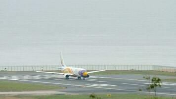 PHUKET, THAILAND NOVEMBER 28, 2017 - Commercial plane Boeing 737 of Nok Air taxiing to the runway of Phuket airport. Airfield on the background of the sea. Tourism and travel concept video