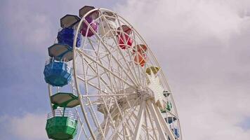 A colorful ferris wheel against a cloudy sky video