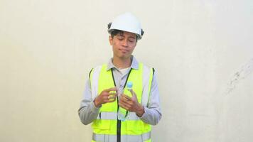 Indonesian worker wear vest and white helmet check report then feel thirsty, drink mineral water. The footage is suitable to use for engineer and safety content media. video