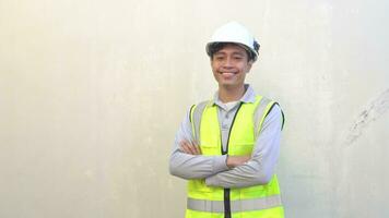 indonesisch Arbeiter tragen Weste und Weiß Helm mit Lächeln Pose. das Aufnahmen ist geeignet zu verwenden zum Ingenieur und Sicherheit Inhalt Medien. video