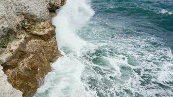 mare onde lavare al di sopra di il rocce. tempesta e cattivo tempo metereologico a mare nel super lento movimento. video