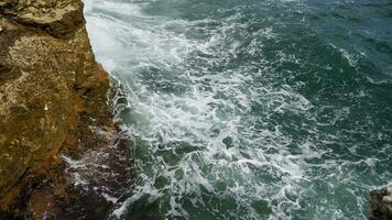 zee golven wassen over- de rotsen. storm en slecht weer Bij zee in super langzaam beweging. video