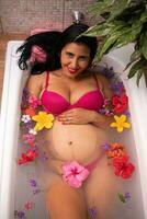 Pregnant woman lying in a bathtub photo