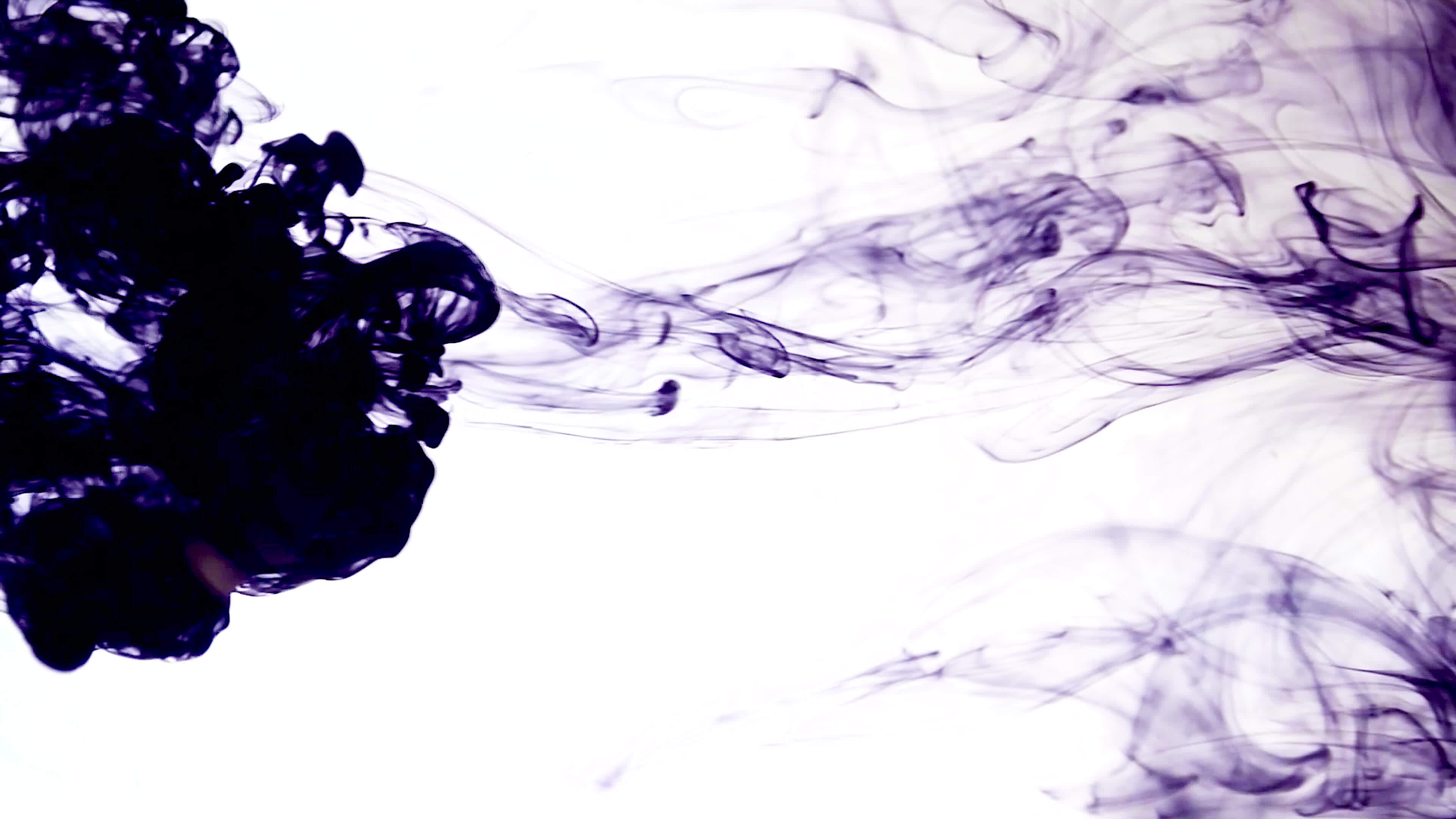 Shiny purple ink dissolves in water on white background, abstract