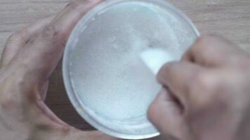 en person är använder sig av en sked till blanda socker in i en skål video