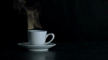 Cup with a hot coffee in black background. Steam from coffee video