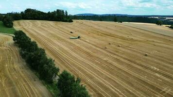 Aerial view of a field and tractor with trailer and loader video