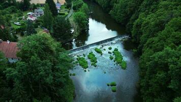 Aerial view of a river with weir and old mill video