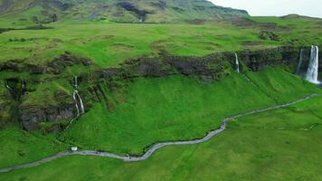 Aerial lenghtwise view of Seljalandsfoss waterfall in Iceland 4K 30p video