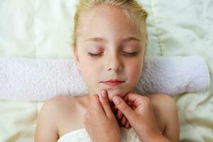 Masseur doing face massage to child. photo