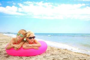 Happy girls lying on pink inflatable circle. photo
