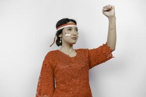 Young woman speaker wearing red kebaya and headband gesturing oration with hands isolated on white background. Indonesia's independence day concept. photo