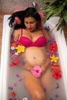 Pregnant woman lying in a bathtub photo